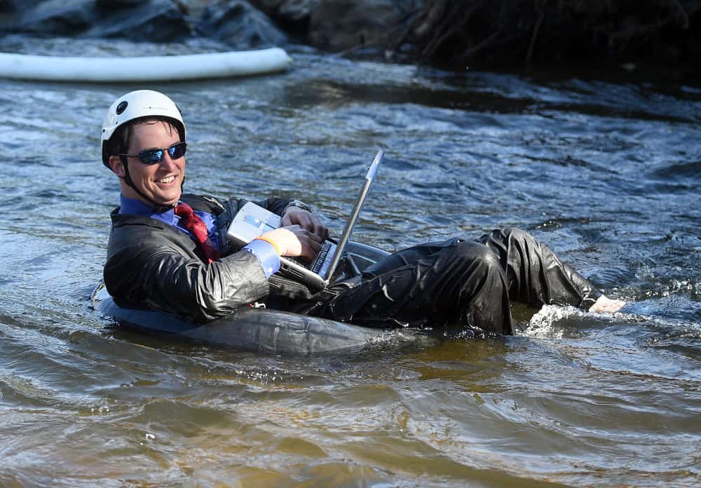 Tube to Work Guy on Computer Floating Down River