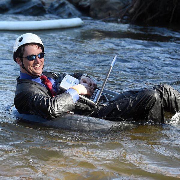 Tube to Work Guy on Computer Floating Down River